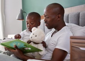 Father reading to his toddler son.